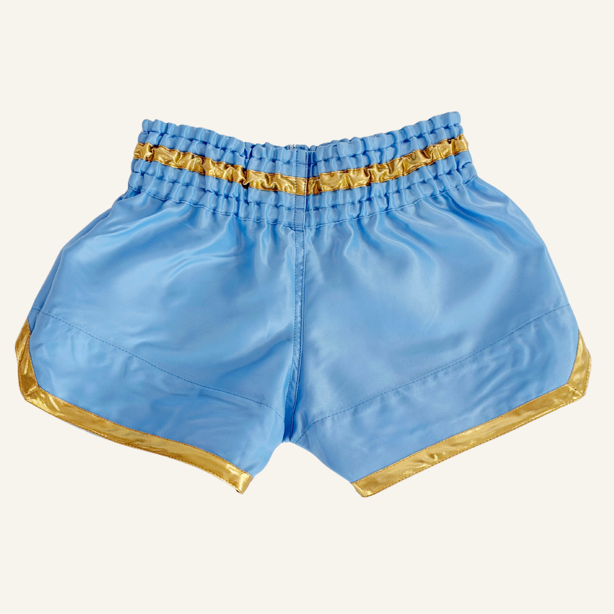 Light blue satin boxing shorts with gold patterned trim, shown flat against a white background.